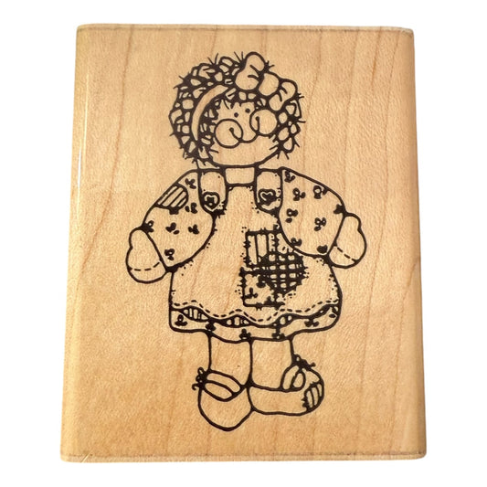 Wooden stamp with a girl doll and dress design.