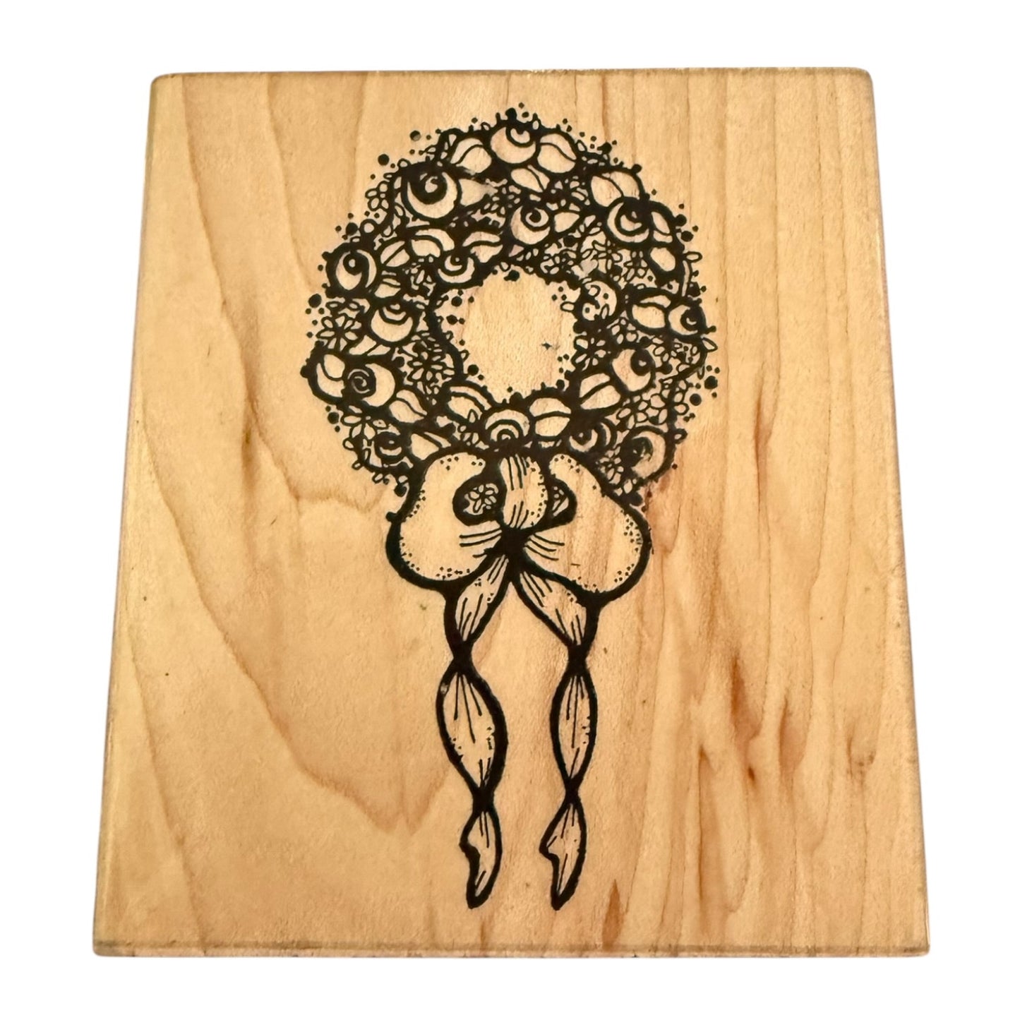 Wooden block with black floral design on a white background