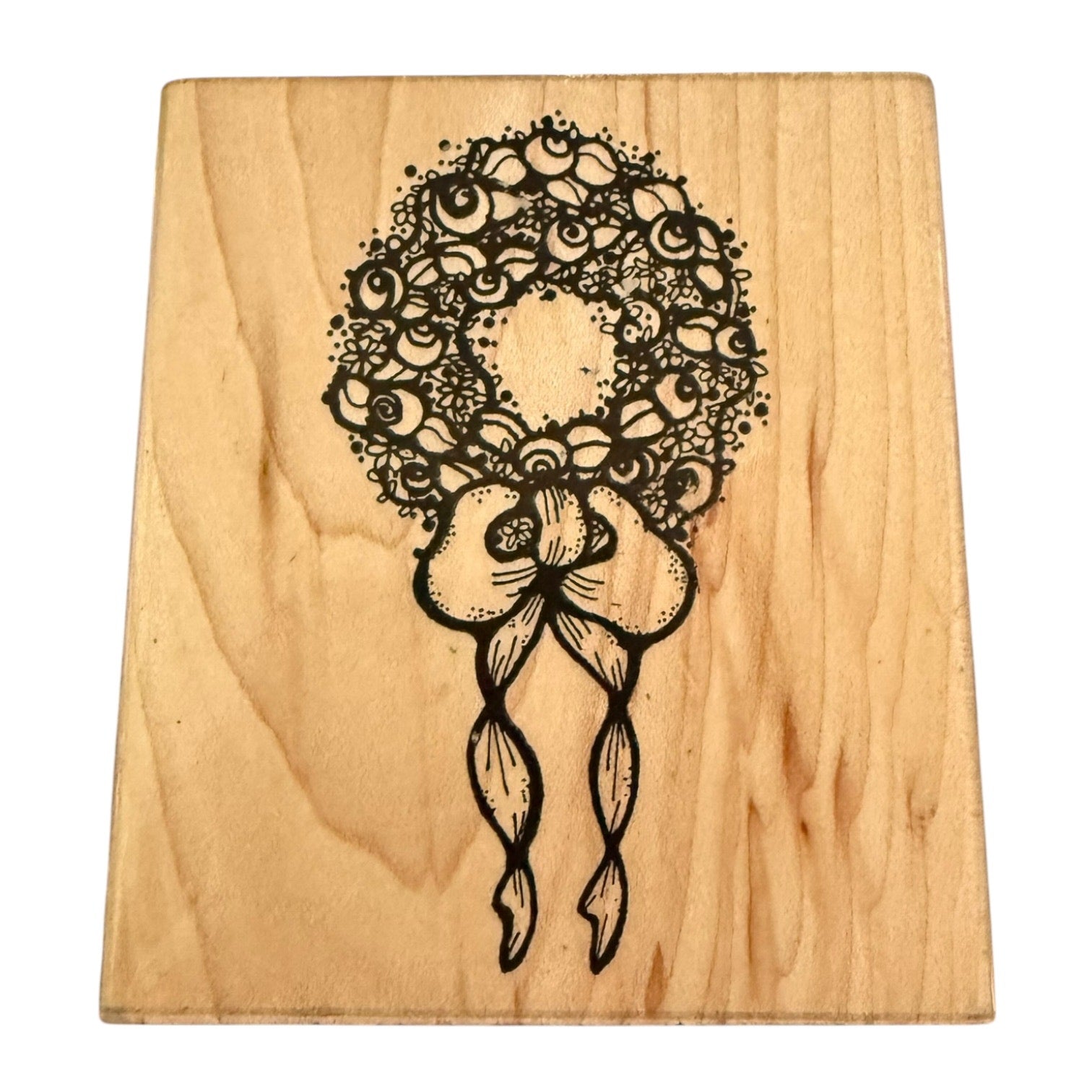 Wooden block with black floral design on a white background