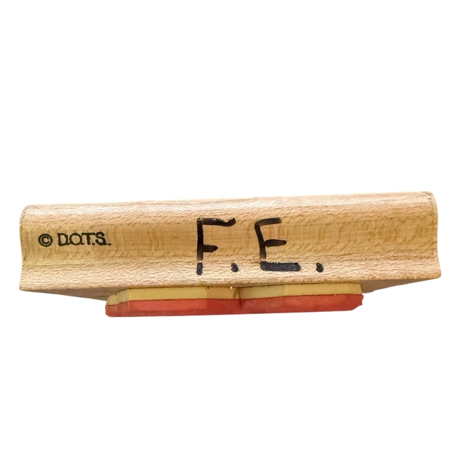 Wooden stamp with 'F.E.' text on a white background