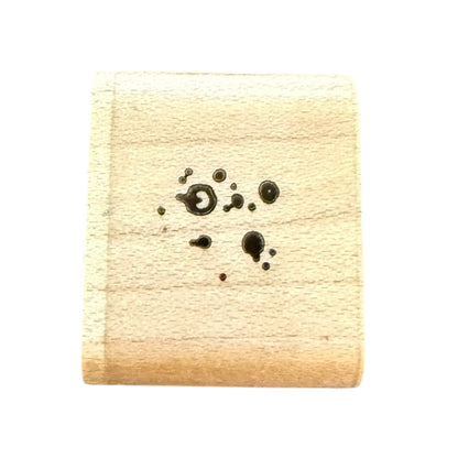 Wooden stamp with black ink dot design on a white background