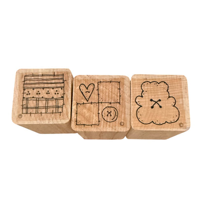 Three wooden stamp blocks with engraved black line drawings, shown side by side on a plain white background.