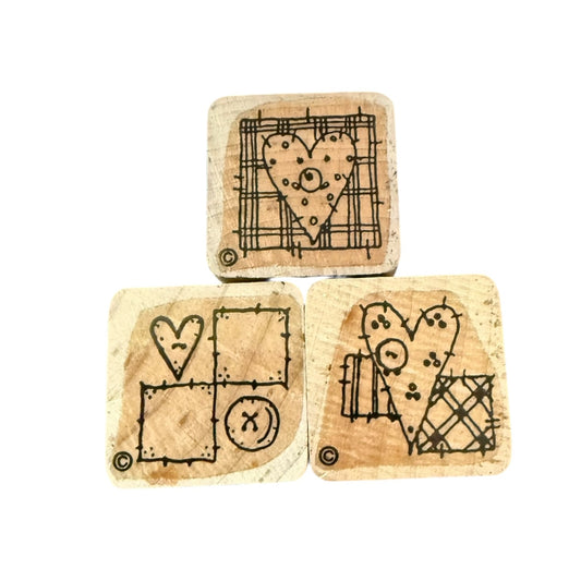 Three wooden stamps with heart designs on a white background