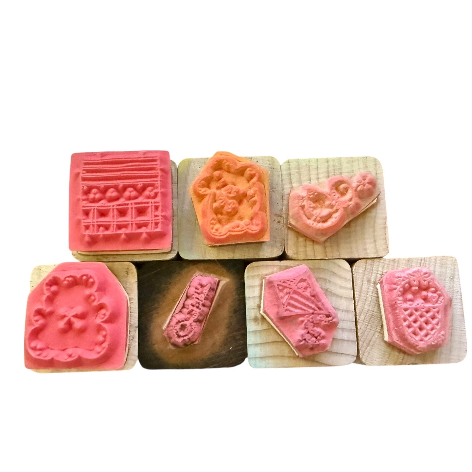 Set of wooden stamps with pink and brown designs on a white background