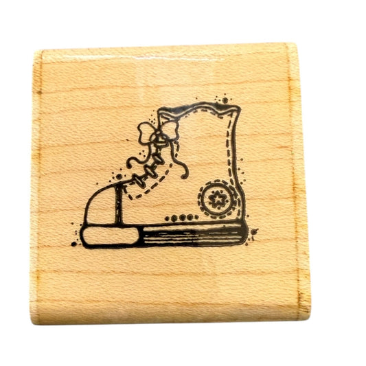 Wooden stamp with a black shoe design on a white background