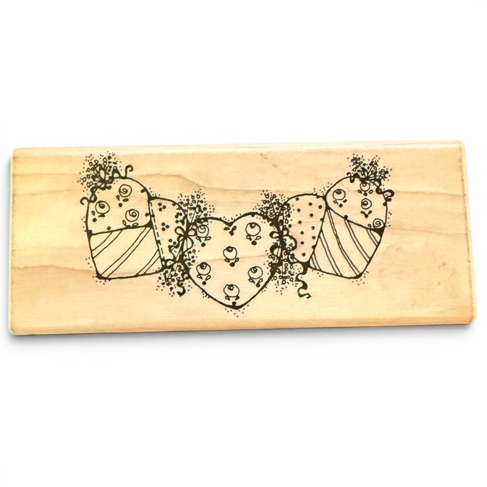 Wooden stamp with decorative heart design on a white background