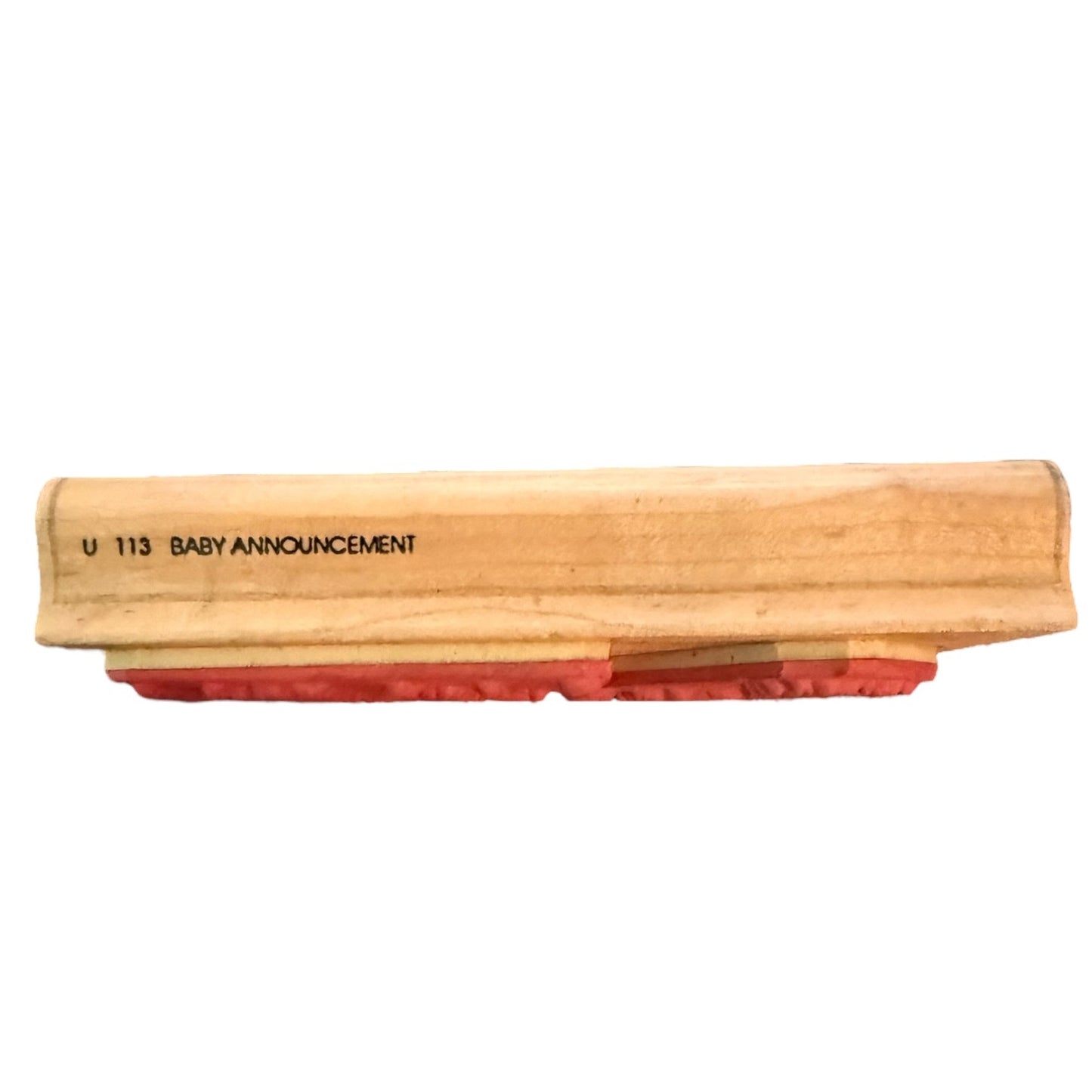 Wooden block with red sandpaper surface and 'U 113 BABY ANNOUNCEMENT' text on a white background