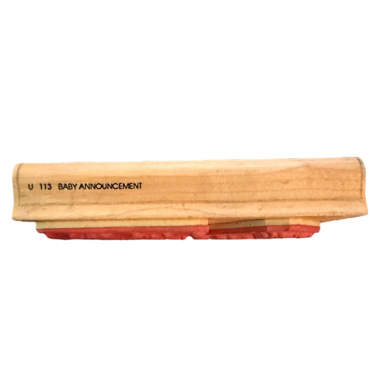Wooden block with red sandpaper surface and 'U 113 BABY ANNOUNCEMENT' text on a white background