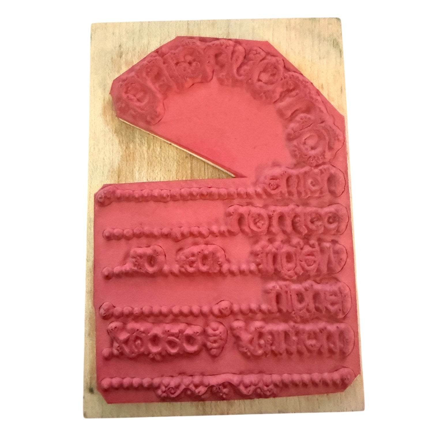 Back of rubber stamp on a wooden block with intricate designs.