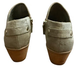 Back of Pair of green suede shoes with brown soles on a white background