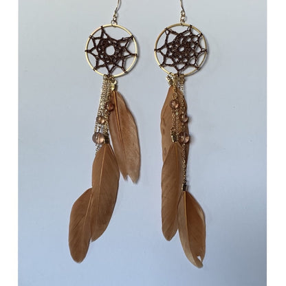 Pair of dreamcatcher earrings with feathers on a light gray background