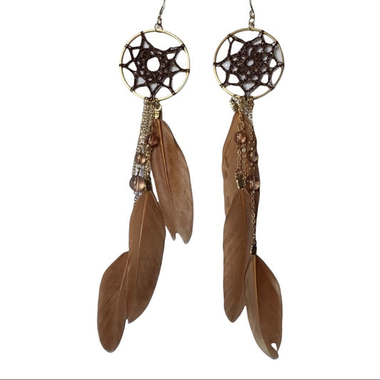 Pair of feather earrings with decorative elements on a white background