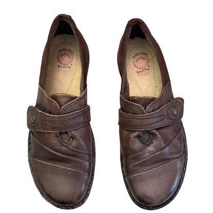 Top of brown leather shoes with a visible brand logo on a white background