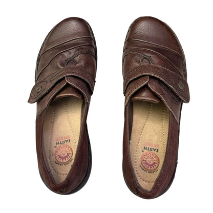 Top of brown shoes with visible brand logo on a white background