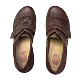 Top of brown shoes with visible brand logo on a white background