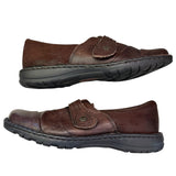 Side of brown leather shoes with black soles on a white background