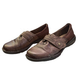 Pair of brown shoes with velcro straps on a white background