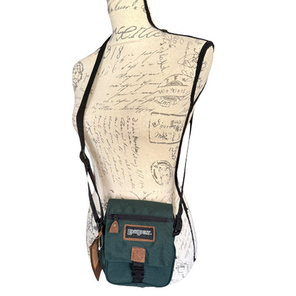 Green crossbody bag on a mannequin with a vintage-style map background