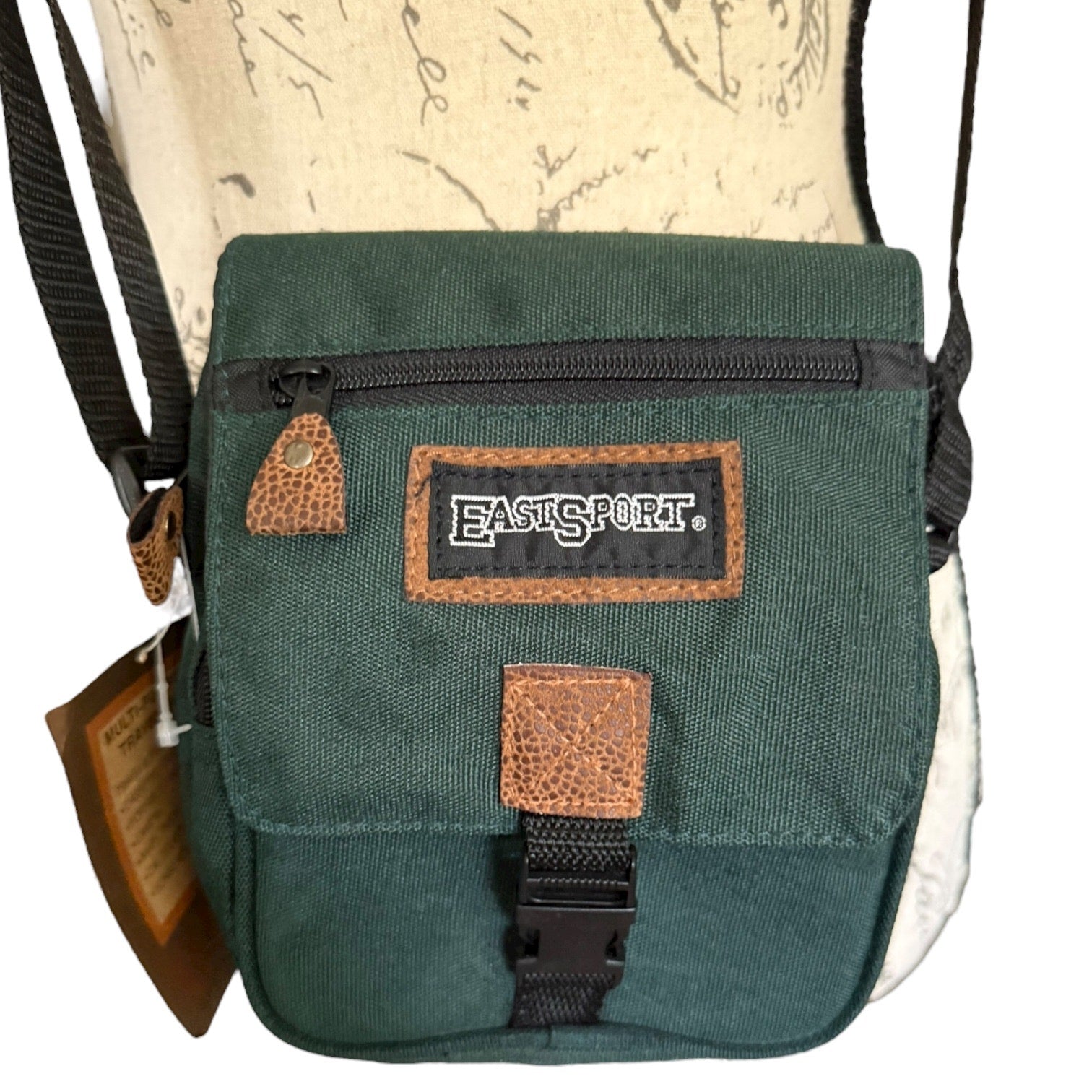 Green crossbody close up with Eastsport label on a white background