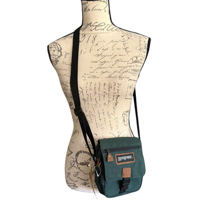 Green crossbody bag on a mannequin with script background