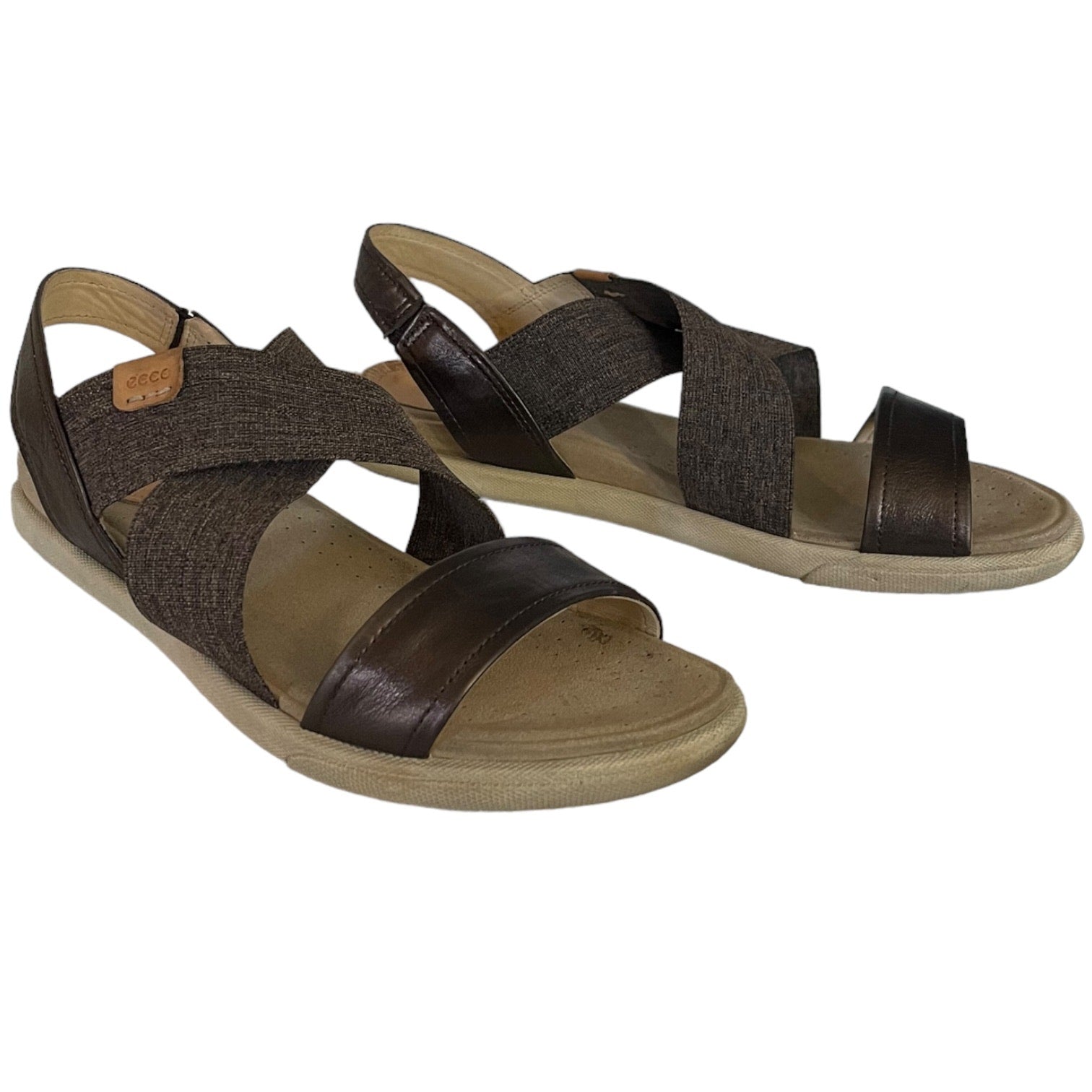 Front side of brown sandals with criss-cross straps on a white background