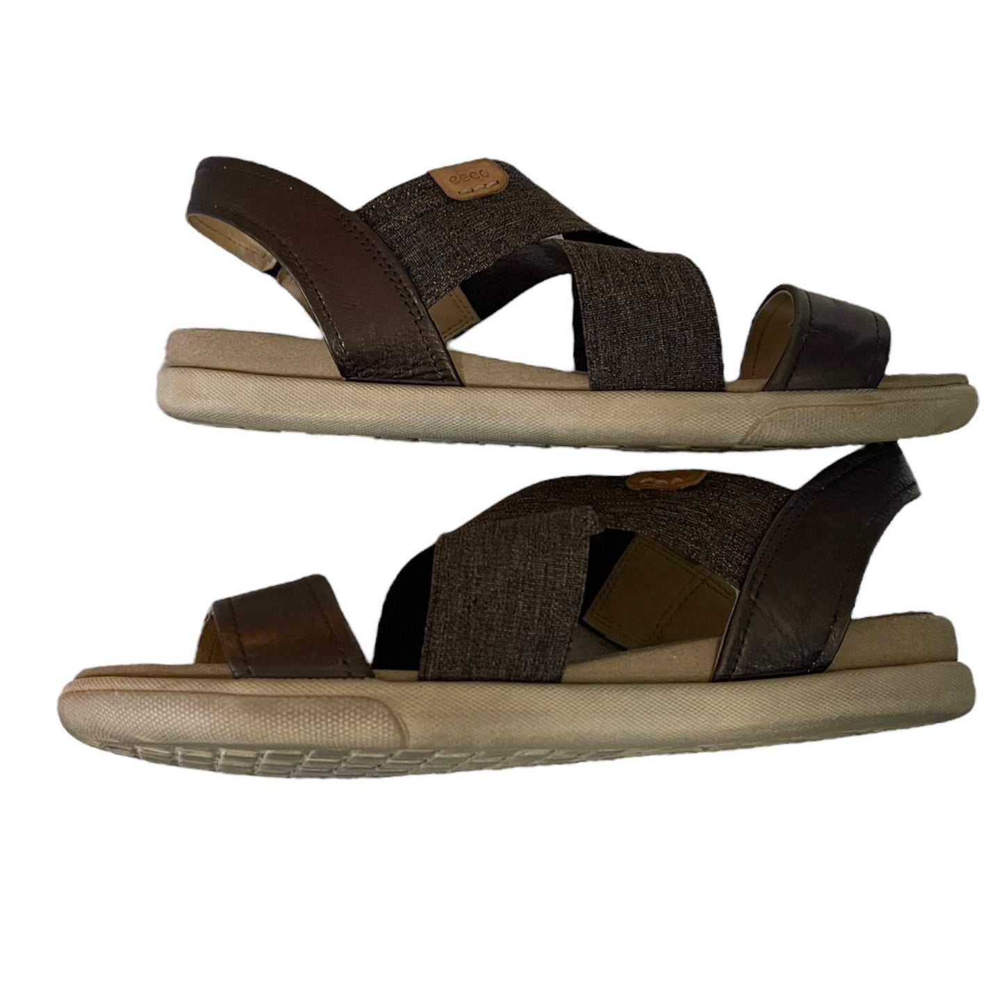 Side of sandals with beige soles on a white background