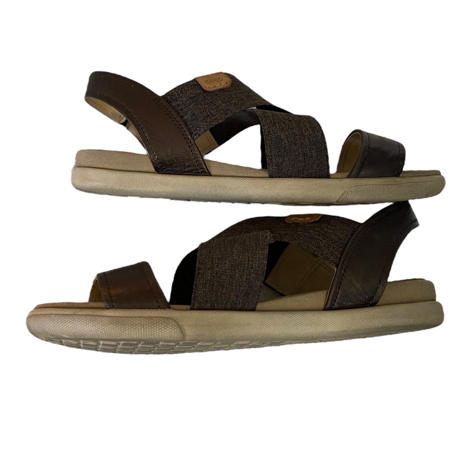 Side of sandals with beige soles on a white background