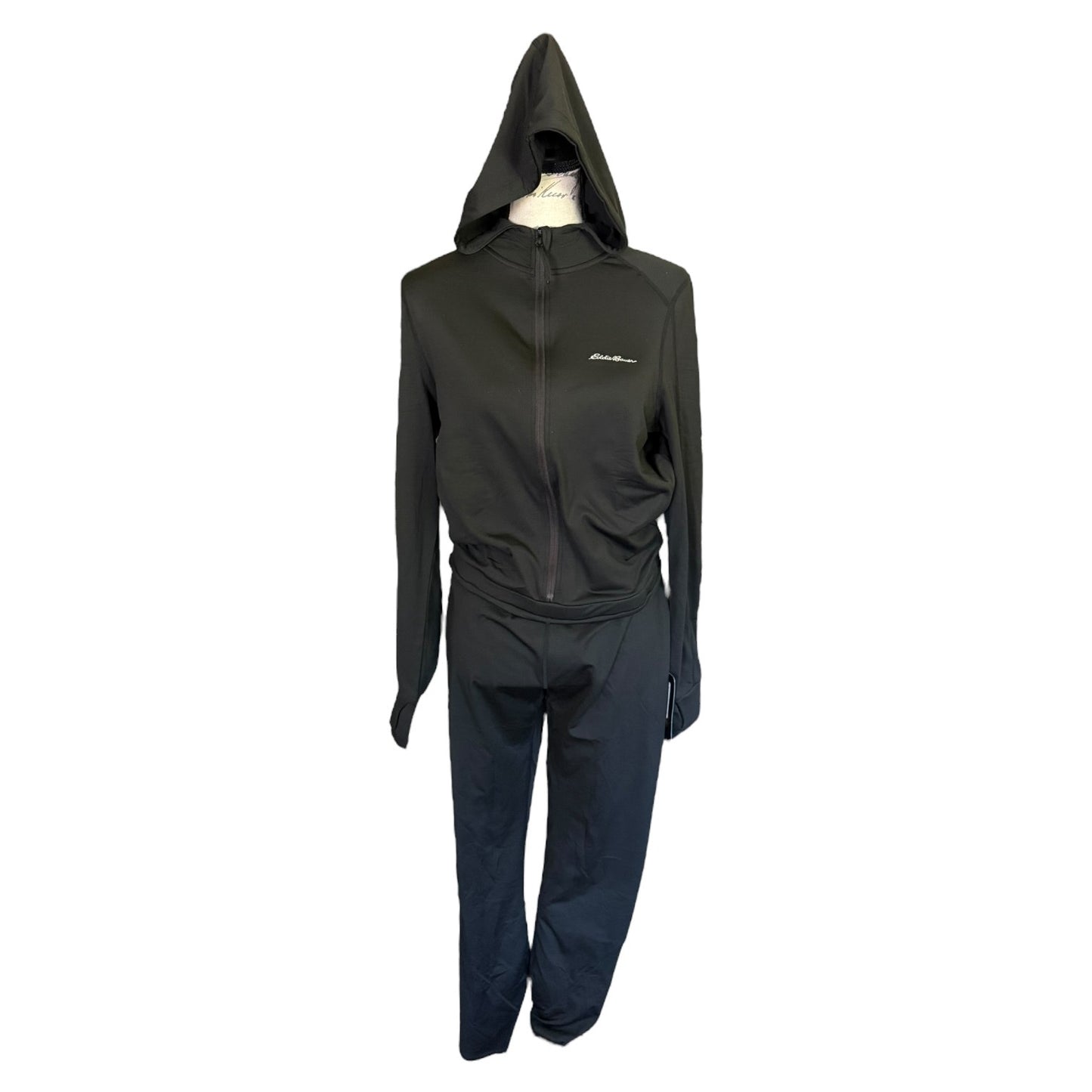 A black athletic jumpsuit consisting of a zip-up hooded jacket and matching pants, displayed on a mannequin against a plain white background.