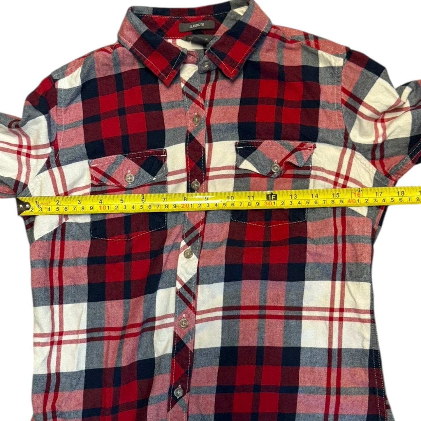 Red, white, plaid shirt with a measuring tape on a white background