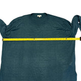 Green sweater with a measuring tape across it on a white background