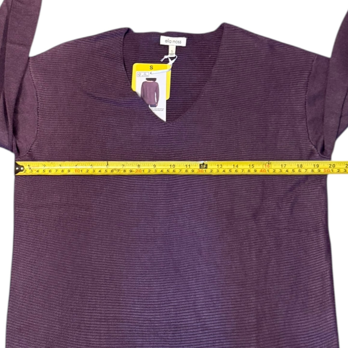 Purple sweater with a measuring tape and tag on a white background