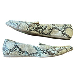 Pair of snake skin patterned flats on a white background