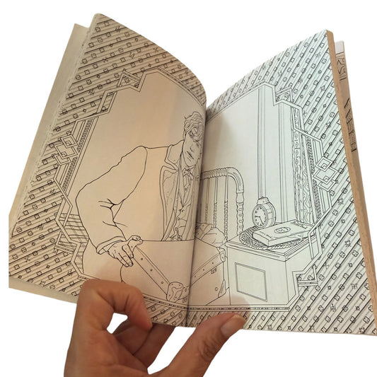 An open coloring book with detailed black line art illustrations coloring pages, held open by a hand against a plain white background.