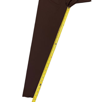 Brown leggings with a measuring tape draped over it on a white background