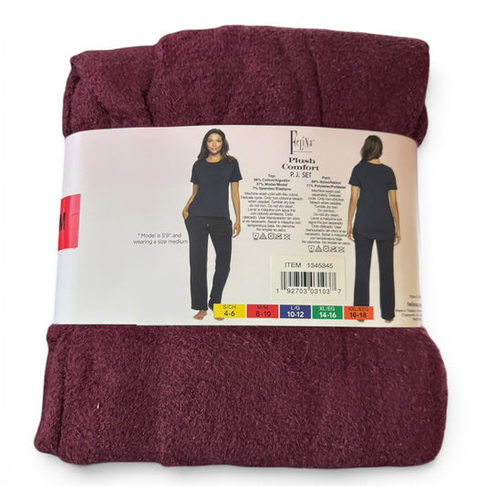 Folded maroon red pajamas with a label on a white background