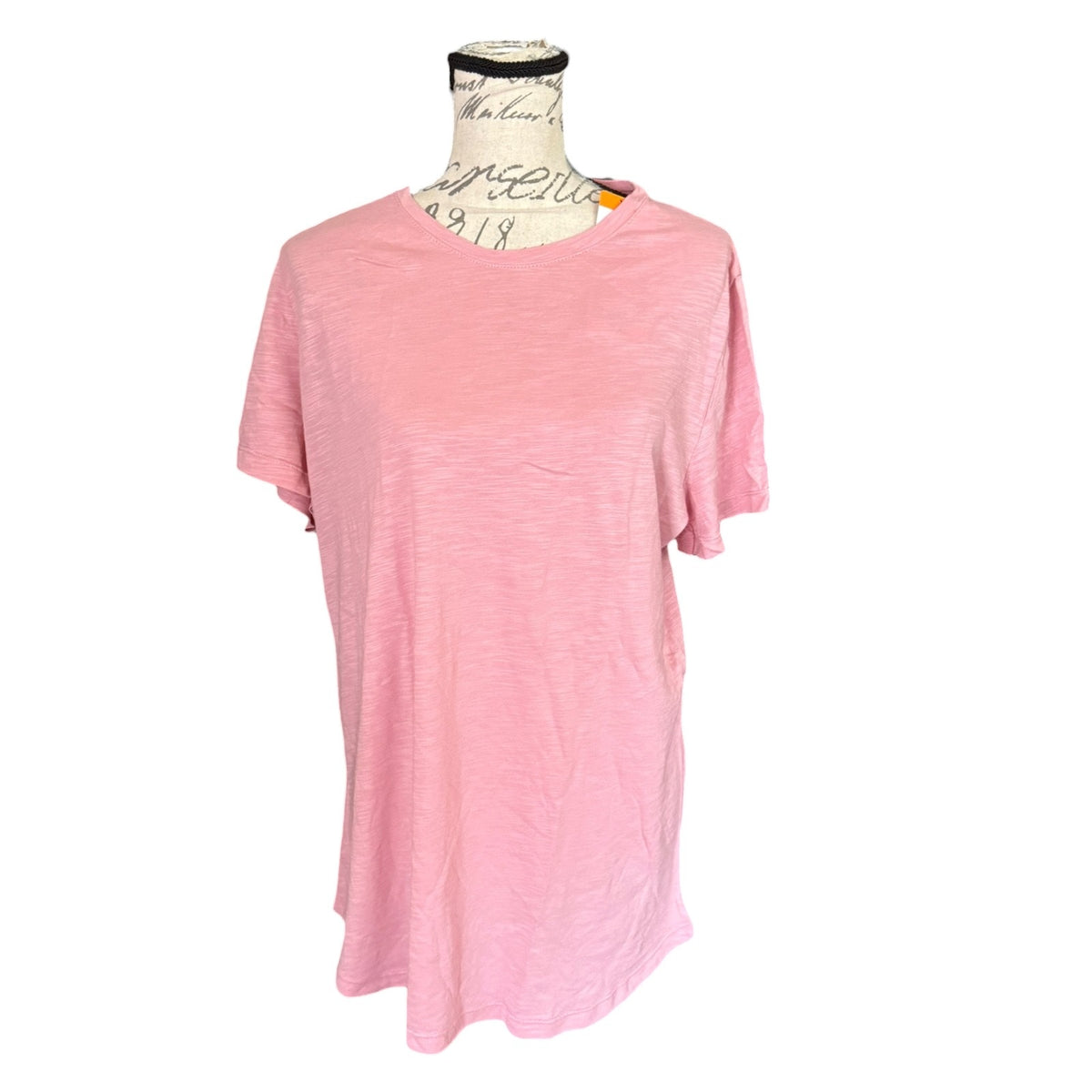A light pink short-sleeve t-shirt displayed on a vintage-style dress form mannequin against a plain white background.