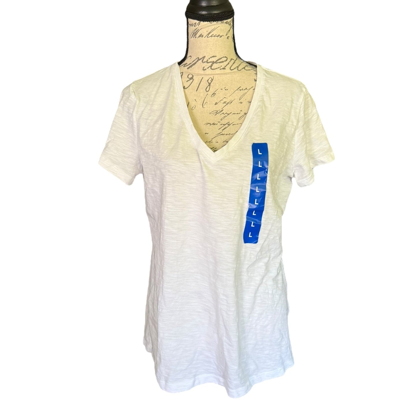 Front of Felina white cotton blend V neck shirt displayed on a mannequin with a visible blue brand tag on the side.