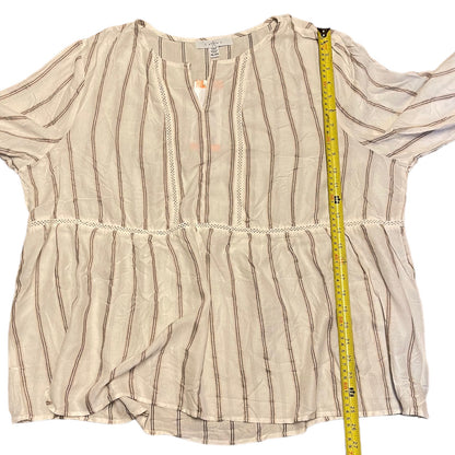 A cream blouse with thin brown vertical stripes and lace trim, laid flat on a white background with a yellow measuring tape running vertically to show the height.