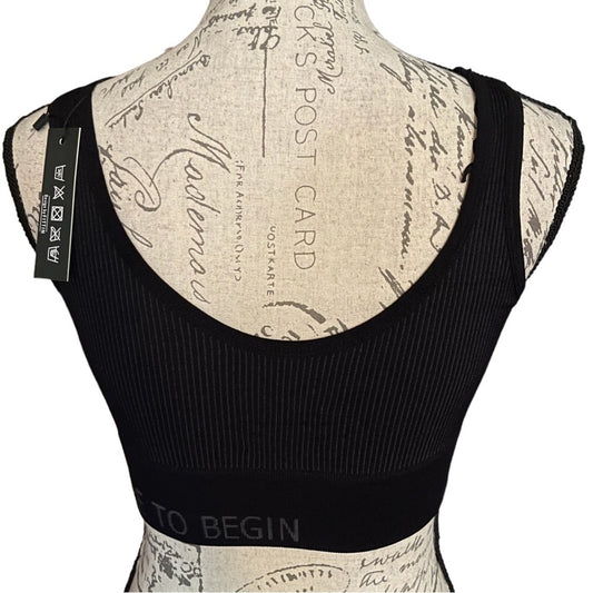 Back of Black ribbed sports bra top displayed on a beige patterned dress form mannequin against a white background.