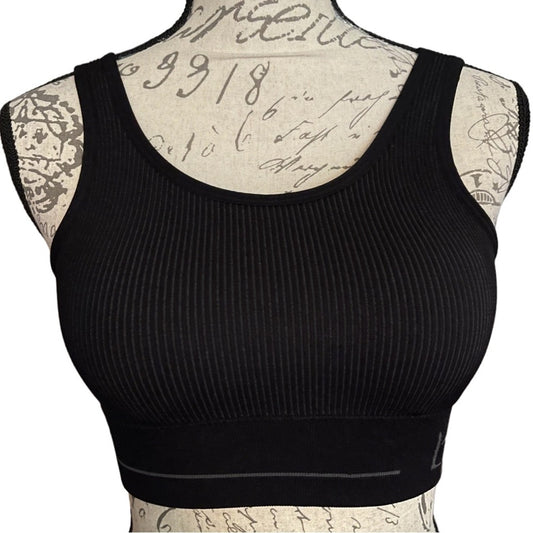 A black ribbed sports bra displayed on a patterned dress form mannequin against a white background.