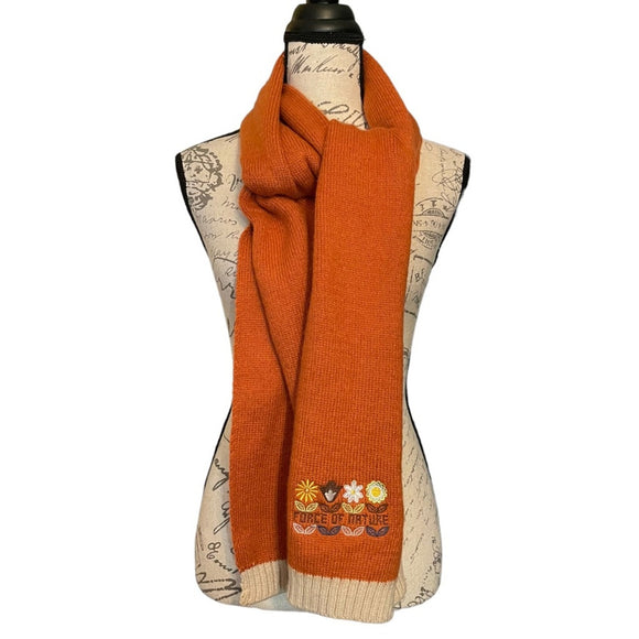 Orange scarf with nature-themed embroidery on a mannequin with a map background