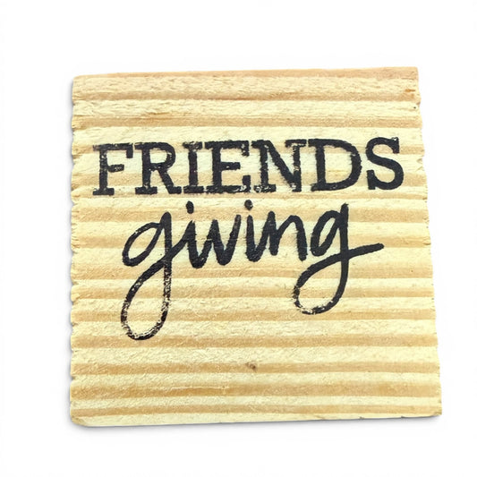 Wooden coaster with 'Friendsgiving' text on a white background