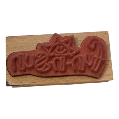 Wooden stamp with red rubber stamp pad on a white background