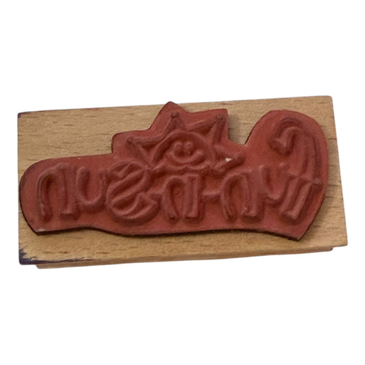 Wooden stamp with red rubber stamp pad on a white background