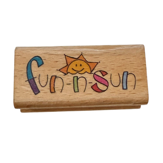 Wooden stamp with 'Fun in Sun' text and sun illustration on a white background