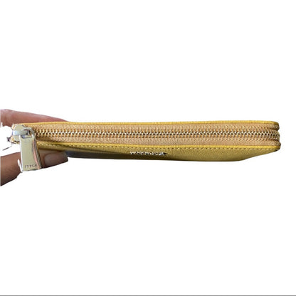 A yellow leather zip-around clutch wallet held by a hand on the left side, featuring a gold-tone zipper and a small gold logo on the front.