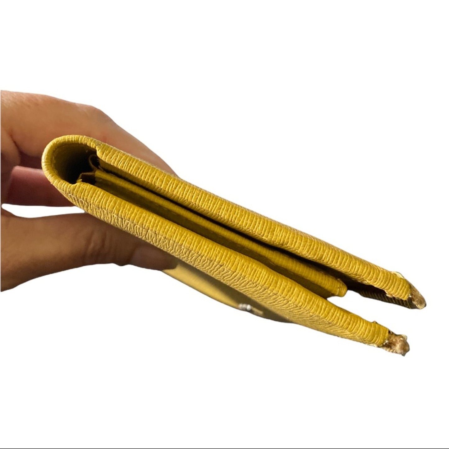 A hand holding a slim, folded yellow textured leather wallet against a plain white background.