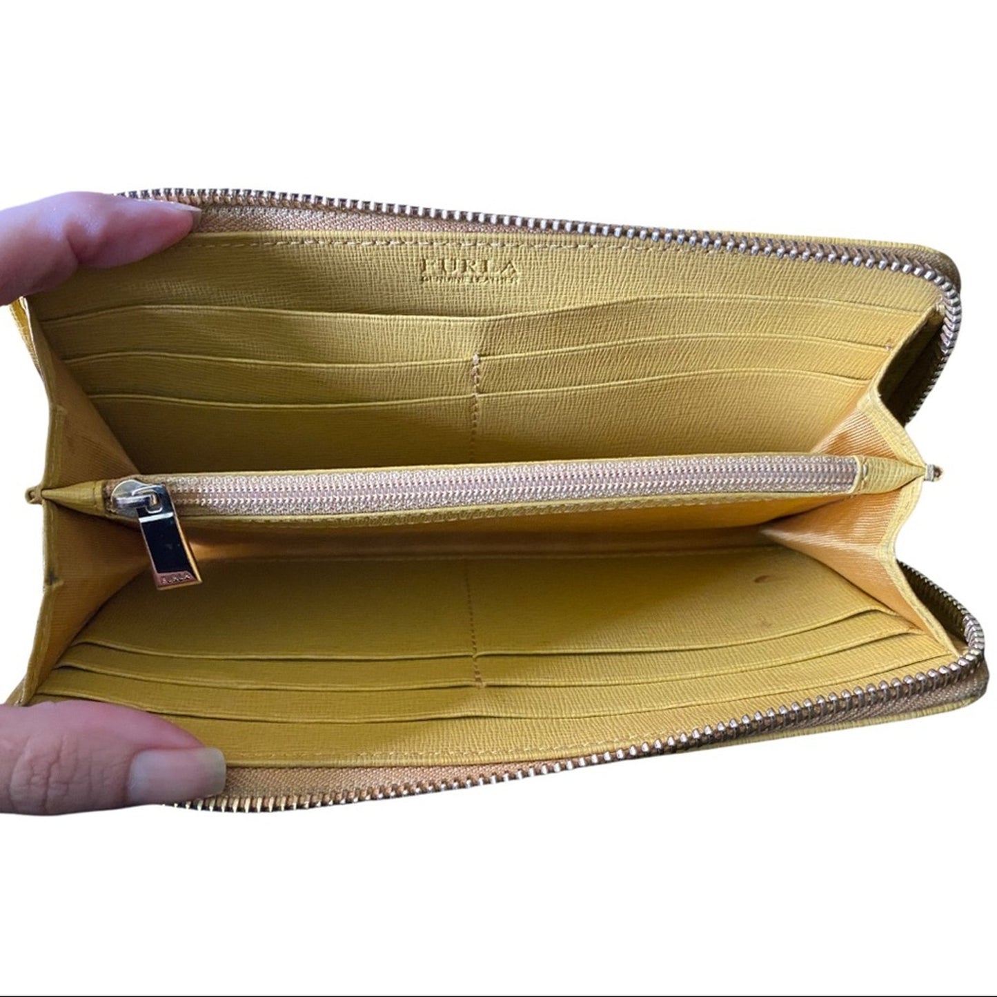 A yellow leather wallet shown open, held by a hand to display its interior. The inside is lined in a matching yellow, with multiple card slots, a zippered pocket, and the brand name 'FURIA' embossed on the upper interior panel.