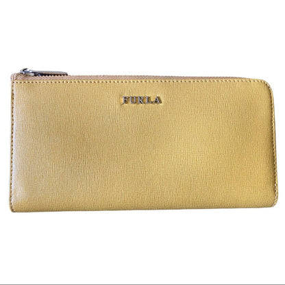 A yellow leather zip-around wallet with the brand name 'FURLA' embossed in gold-tone lettering on the front, set against a plain white background.