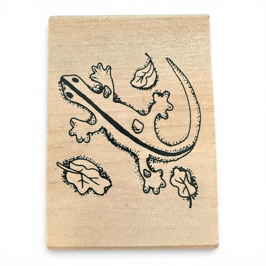 Wooden stamp with a black lizard design on a white background